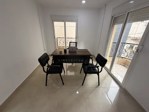 Private office with desk, visitor chairs, and balcony light